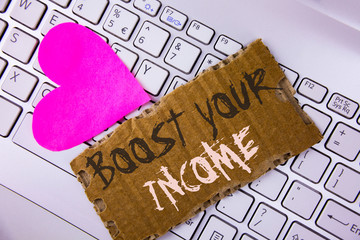 Word writing text Boost Your Income. Business concept for improve your payment Freelancing Part time job Improve written Tear Cardboard Piece placed the Laptop Pink Heart next to it.