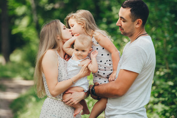 Portrait of happy family with two daughters standing outdoors