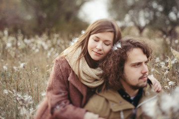 Fototapeta premium Young happy caucasian couple expecting a baby. Pregnant woman and her husband walking and having fun together outdoors in the autumn. Family, parenthood, love, happiness concept.