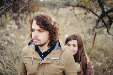 Fototapeta premium Young happy caucasian couple expecting a baby. Pregnant woman and her husband walking and having fun together outdoors in the autumn. Family, parenthood, love, happiness concept.