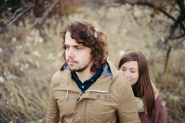 Fototapeta premium Young happy caucasian couple expecting a baby. Pregnant woman and her husband walking and having fun together outdoors in the autumn. Family, parenthood, love, happiness concept.