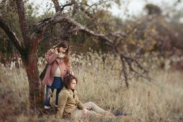 Young happy caucasian couple expecting a baby. Pregnant woman and her husband walking and having fun together outdoors in the autumn. Family, parenthood, love, happiness concept.