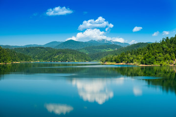 Fototapeta na wymiar Croatia, beautiful lake in Gorski kotar, Lokve, Risnjak mountain in background, reflection in watter