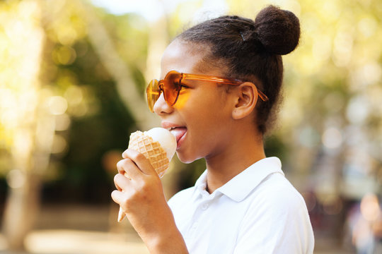 Cute girl in bright sunglasses eating ice-cream