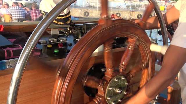 Ece Marina, Fethiye, Turkey - 11th of July 2019: 4K Sunset tour on the board of Seaside - Captain steering the wheel of unberthing ship