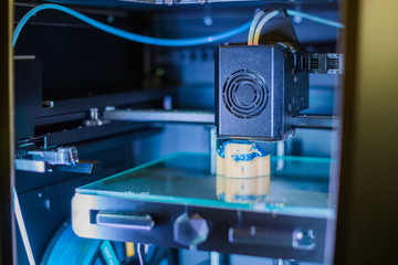 3D printer prints physical 3D model with plastic wire filament at modern technology exhibition. Additive technologies, science and futuristic concept