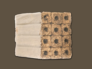 Fuel briquettes folded in rows on a white background.