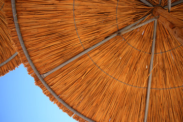 Summer background with blue sky and sun umbrella