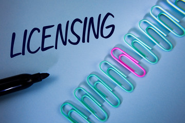 Word writing text Licensing. Business concept for Grant a license Legally permit the use of something Allow activity written Plain Blue background Paper Clips and Marker next to it.