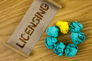 Conceptual hand writing showing Licensing. Business photo showcasing Grant a license Legally permit the use of something Allow activity written Cardboard Paper piece wooden background Paper Ball