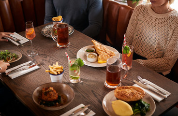 Close Up Of Friends Meeting For Meal In Traditional English Pub