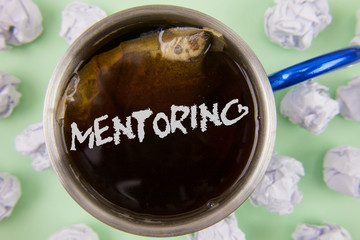 Text sign showing Mentoring. Conceptual photo To give advice or support to a younger less experienced person written Black Tea in Cup within Crumpled Paper Balls plain Green background.