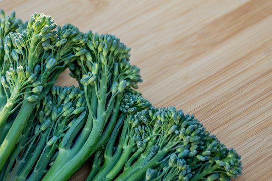Bunch of fresh broccolini on a wooden board background. Healthy eating. Cooking ingredient