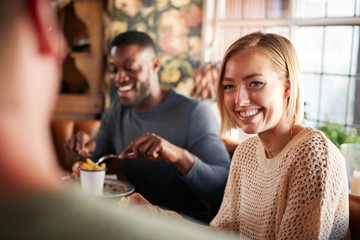 Group Of Friends Meeting For Meal In Traditional English Pub
