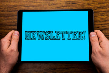 Text sign showing Newsletter Motivational Call. Conceptual photo Bulletin periodically sent to members of group written Tablet Screen holding in Hand wooden background.