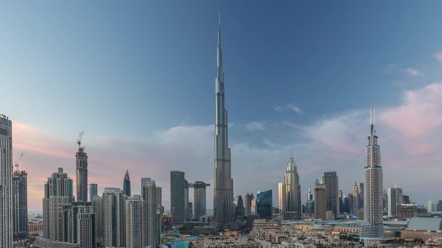Dubai Downtown skyline day to night transition timelapse with Burj Khalifa and other towers paniramic view from the top in Dubai, United Arab Emirates. Traditional and modern buildings. Traffic on