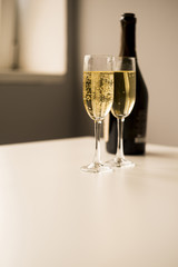 Champagne glasses with bottle on white table