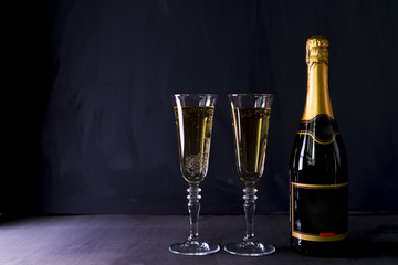 Glasses of champagne with bottle on table