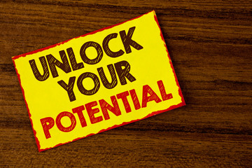 Handwriting text writing Unlock Your Potential. Concept meaning Reveal talent Develop abilities Show personal skills written Yellow Sticky note paper the wooden background.