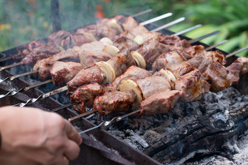 The meat is fried barbecue on a skewer in the garden with smoke