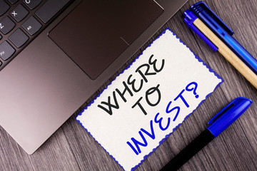 Word writing text Where To Invest Question. Business concept for Right Place Stock Share to spend your savings in written White Sticky Note Paper the wooden background Laptop Markers