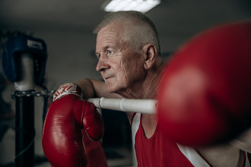 An elderly boxer in the ring thinks about his defeat.
