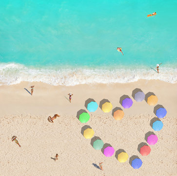 People on beach and heart shape made of umbrellas