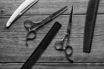 Barber tool. Barber scissors. Barber tool top view. Scissors, razor and hairbrush on vintage wooden...