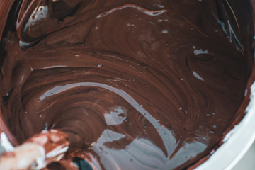 stirring brown paint with a brush