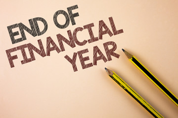 Writing note showing End Of Financial Year. Business photo showcasing Taxes time accounting June database cost Sheets written Plain background Pencils next to it.