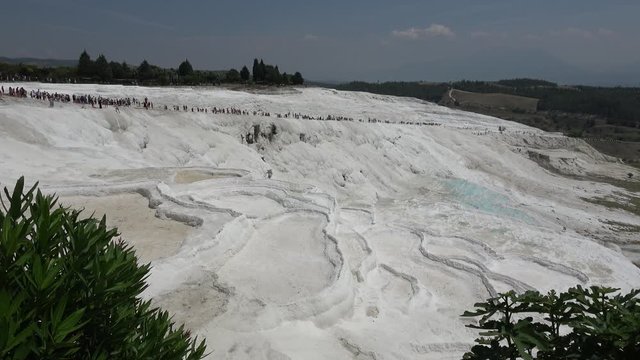 Pamukkale, Denizli, Turkey - 16th of July 2019: 4K Viewing on white sinter terraces and walking people