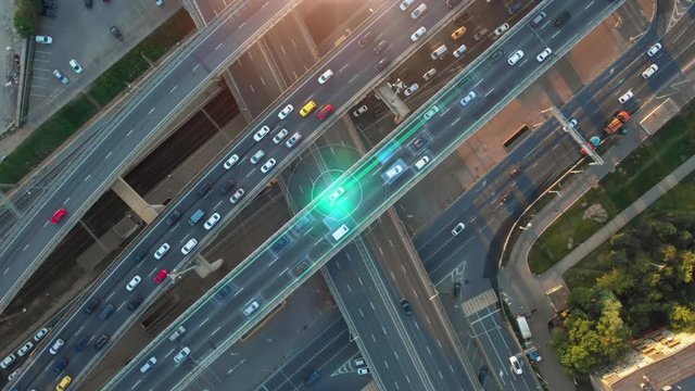Beautiful aerial presentation of the autonomous cars self-driving concept on multi-level highway in Moscow. Direct view from above to the road traffic in a big city on the sunny evening.