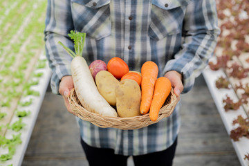 Farmer holding a basket of organic vegetables.
