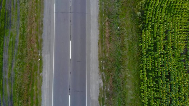 Top view drone flying above the road with driving cars and trucks. Vertical direction.