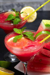 Two watermelon smoothies with lemon, lime, ice and slices of watermelon