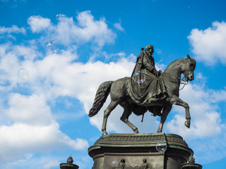 Black statue with floating soap bubbles