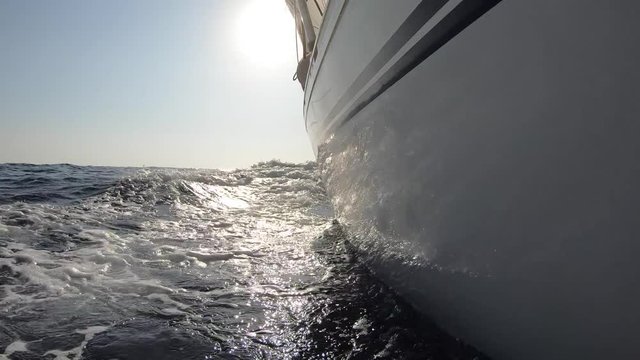 Sailing boat at sea in the summer, detail of the hull and waves - Slow motion