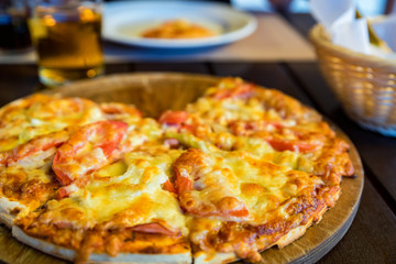 Delicious fresh pizza with tomatoes, salami and melted cheese close