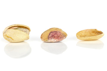 Group of two whole one piece of ripe green pistachio in closeup in row isolated on white background