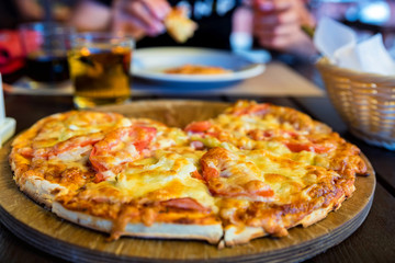 Delicious fresh pizza with tomatoes, salami and melted cheese close