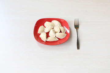 Healthy Eating - On the table are dumplings in a plate and a fork.