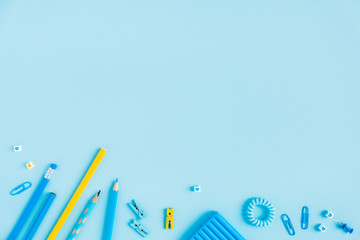 School accessories on a blue background. Pastel colored.