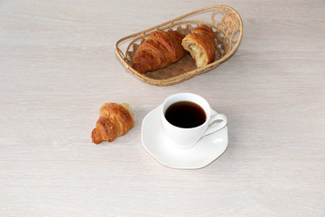 Close-up - breakfast, cup of coffee and croissants.