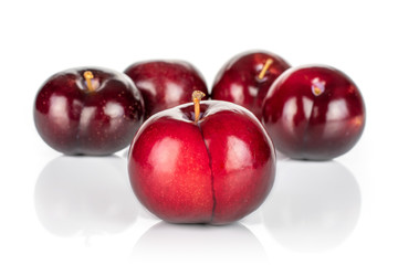 Group of five whole ripe red round plum arranged symmetrically isolated on white background