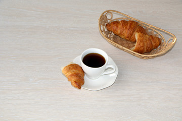 Close-up - breakfast, cup of coffee and croissants.