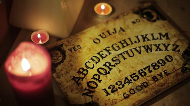Top down shot of Ouija Board with Candles