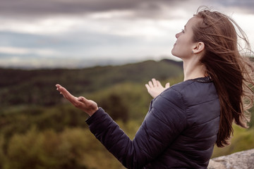 Christian worship and praise. A young woman is praying and worshiping in the evening.