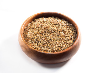 Cumin seeds (Cuminum), jeera in a wooden cup on a white background