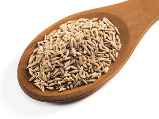 Cumin seeds (Cuminum), Jeera in wooden spoon on a white background diagonally