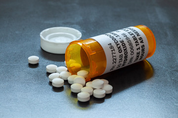 Prescription bottle with backlit Oxycodone tablets. Oxycodone is a generic prescription opioid. A...